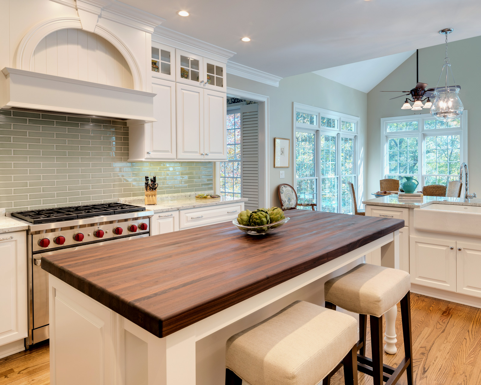 Walnut kitchen island with thick solid wood countertop in a white residential kitchen
