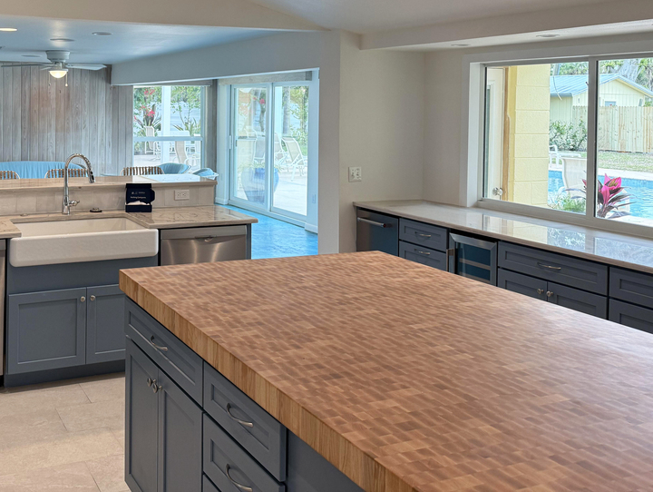 End-grain maple island countertop in a contemporary kitchen with dark cabinetry and large windows