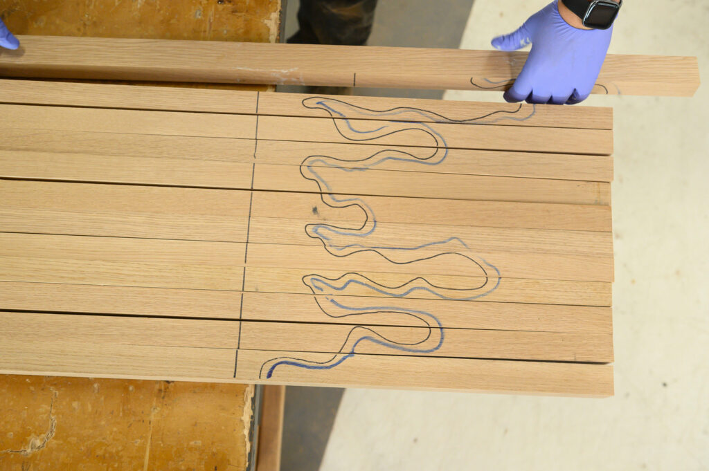 Marked grain layout across solid wood boards during material selection and surface planning.