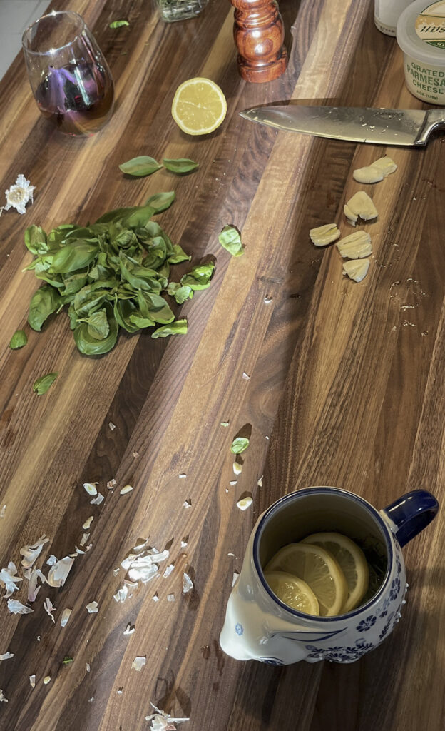 Walnut butcher block kitchen island in active daily use with food preparation and natural surface wear visible