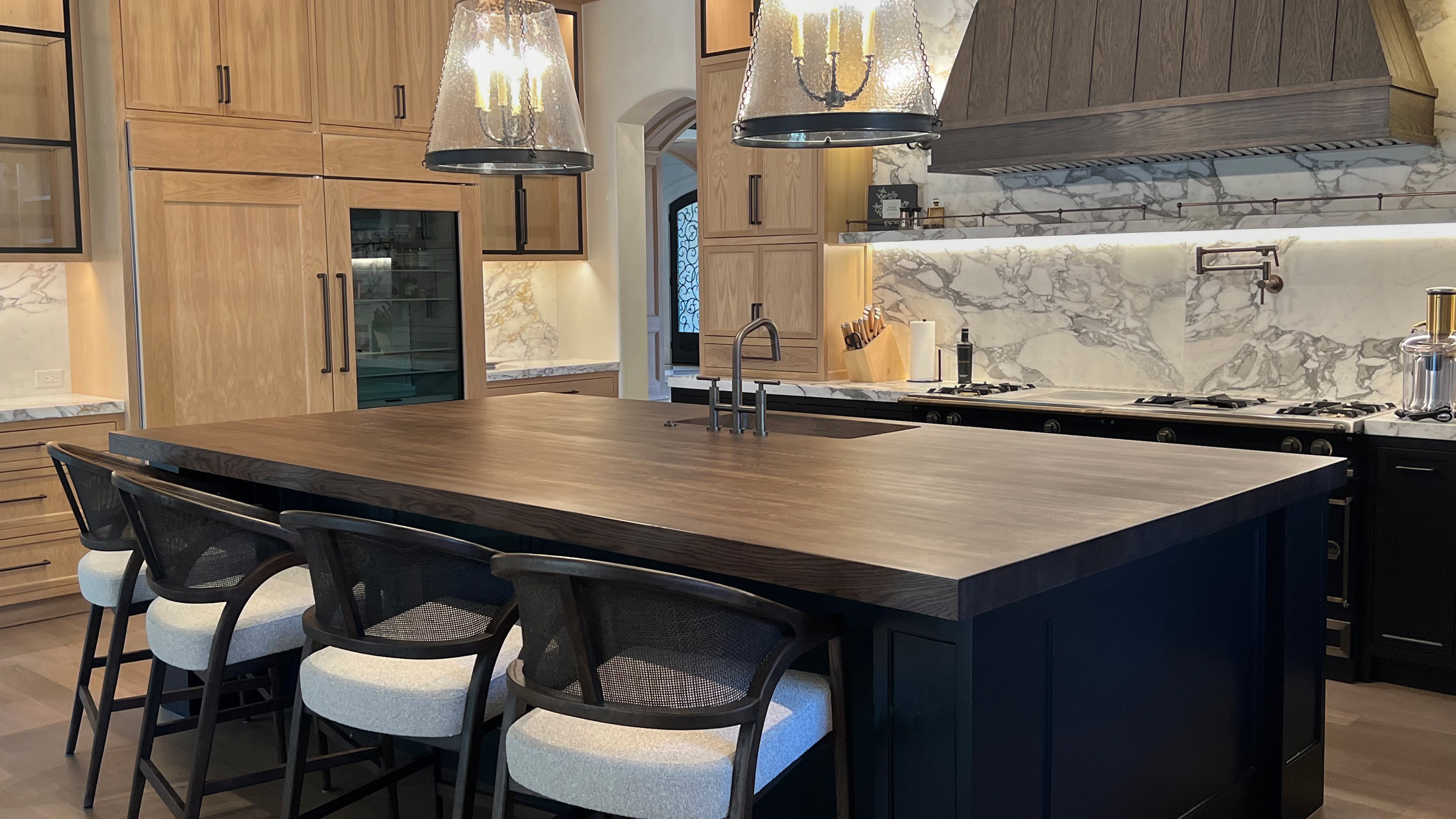 Custom butcher block countertop in white oak with color-matched stain on large kitchen island in a luxury residential kitchen
