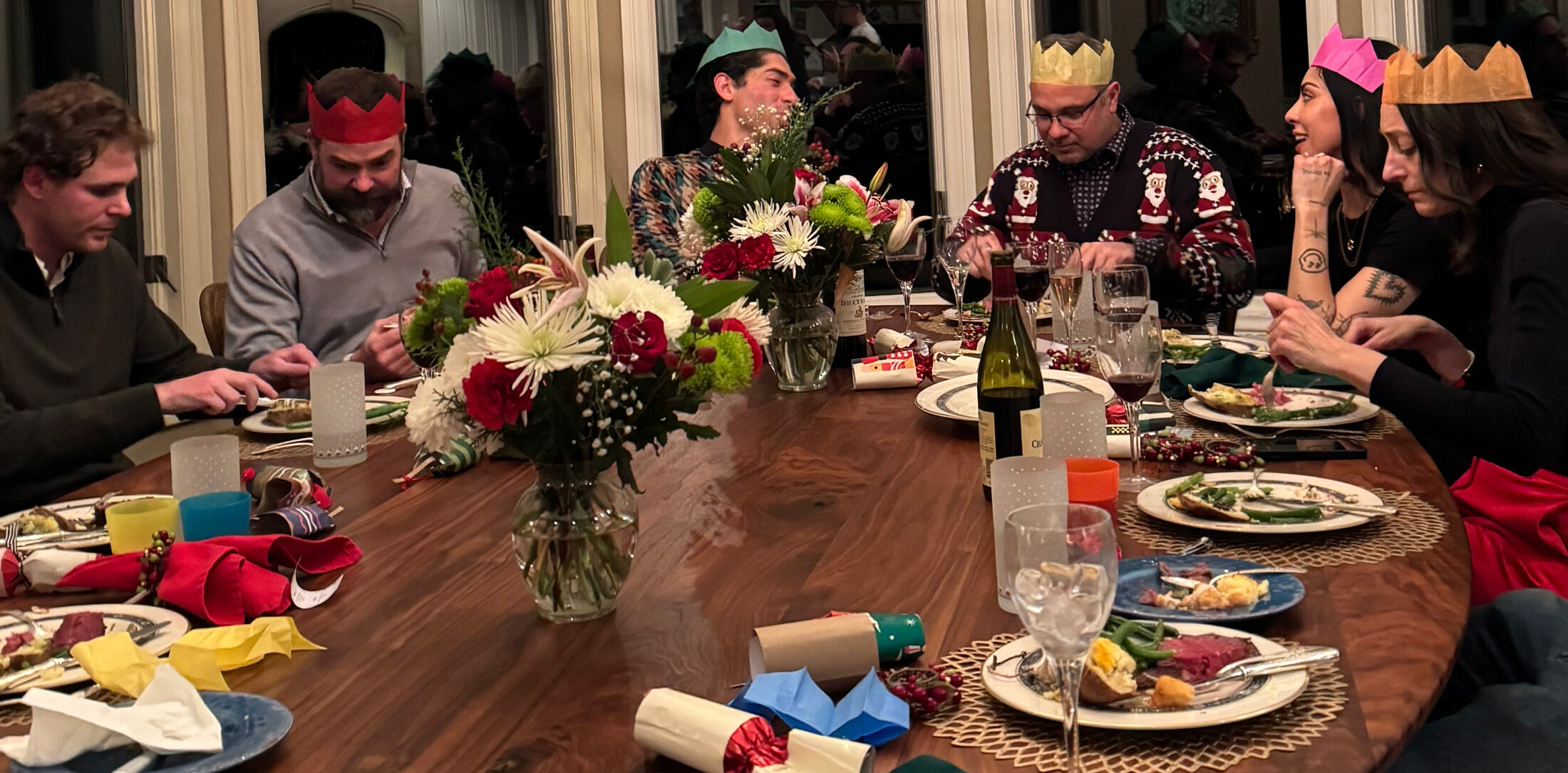 People gathered around a lar ge solid walnut dining table during a holiday meal