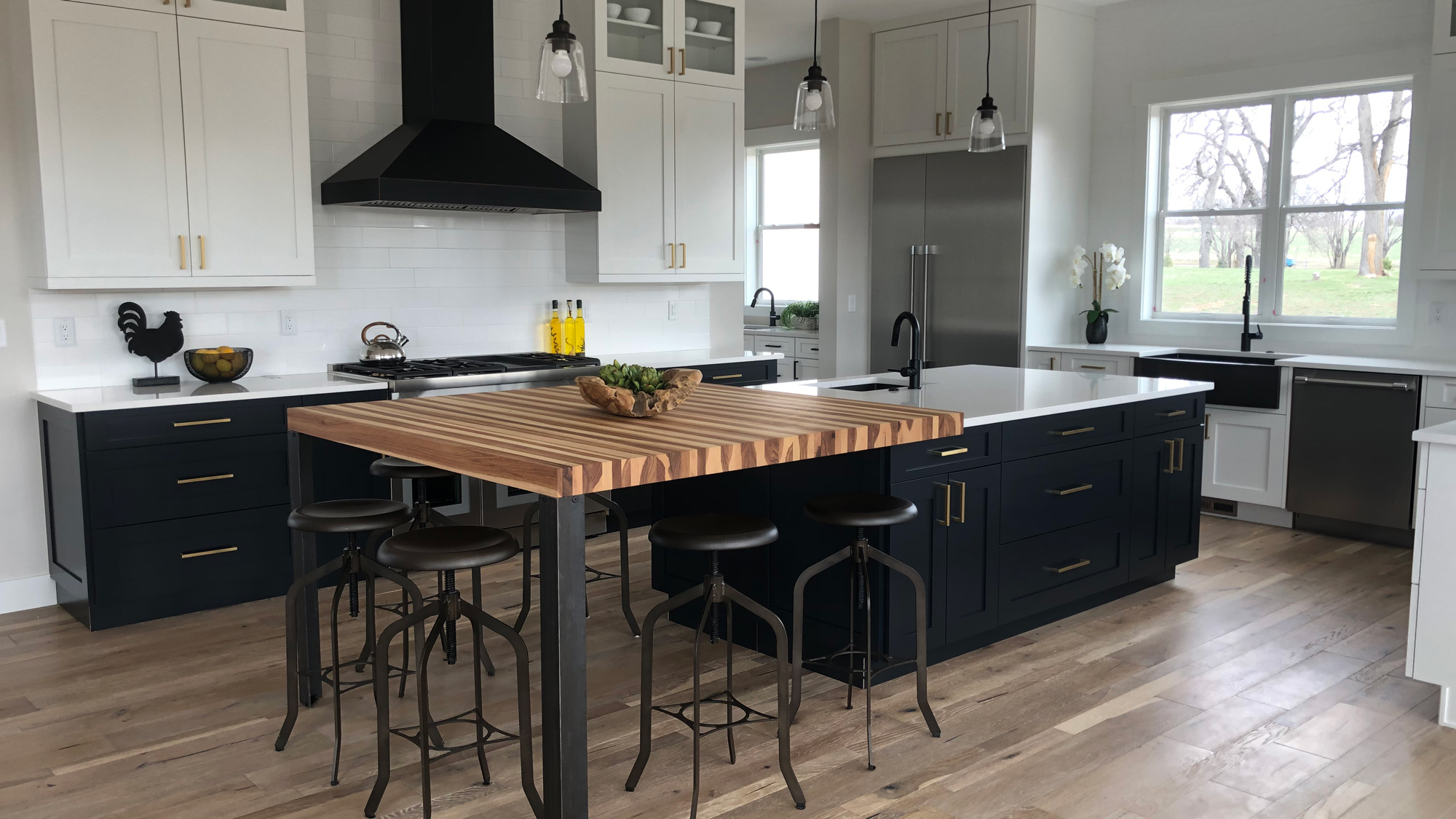 Calico hickory butcher block dining extension on a navy kitchen island with counter stools